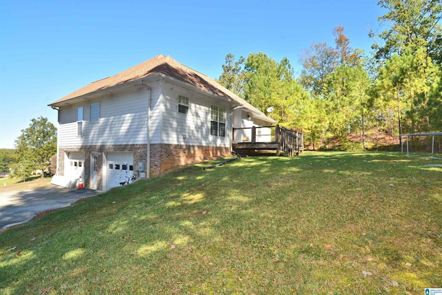 view of property exterior featuring a deck, a trampoline, a garage, and a lawn