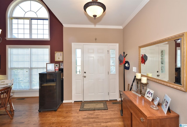 entrance foyer featuring crown molding, a wealth of natural light, and hardwood / wood-style floors