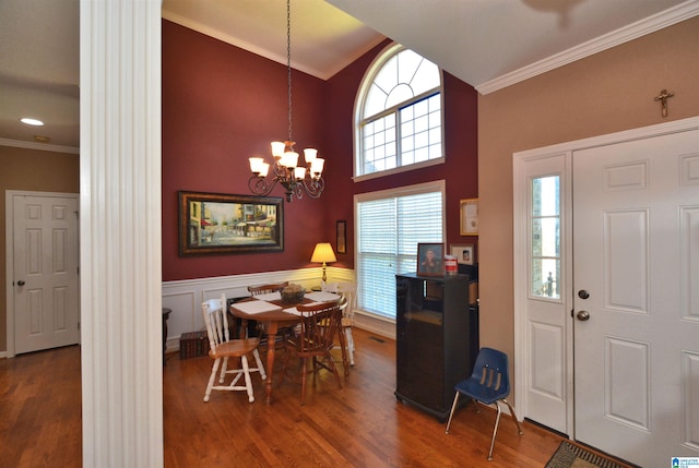 foyer entrance with dark hardwood / wood-style floors, ornate columns, and a wealth of natural light