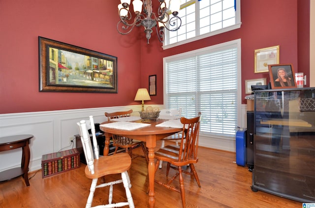 dining room featuring a wealth of natural light, a notable chandelier, and wood-type flooring