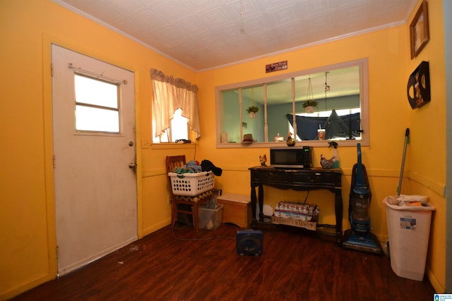 interior space with dark hardwood / wood-style flooring and ornamental molding