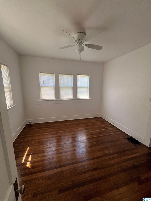 empty room featuring ceiling fan and dark wood-type flooring