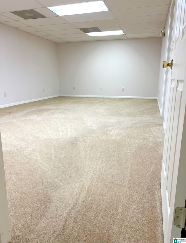 carpeted spare room featuring a paneled ceiling