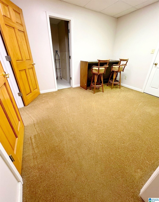 carpeted home office with a drop ceiling