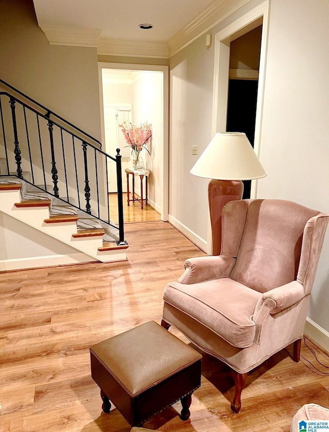 sitting room featuring crown molding and light hardwood / wood-style flooring