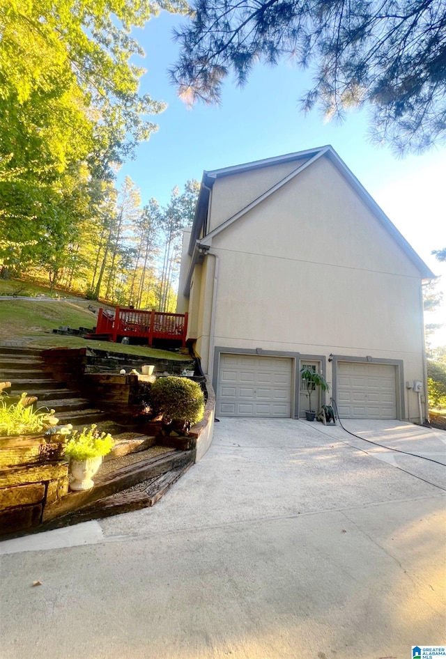 view of side of home with a deck and a garage