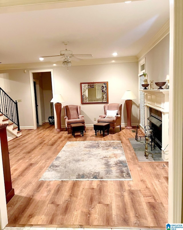 sitting room with crown molding, light hardwood / wood-style flooring, and ceiling fan