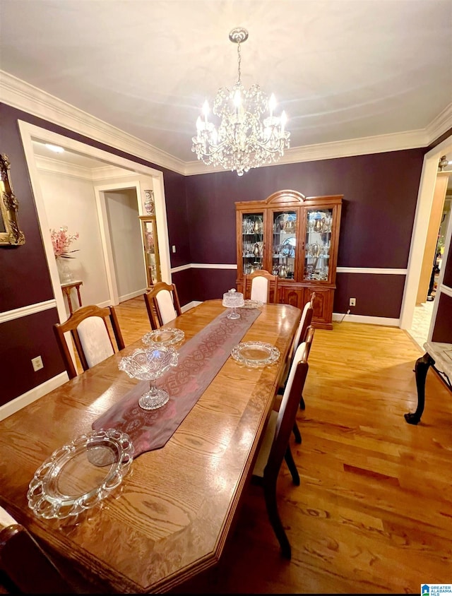 dining space with an inviting chandelier, crown molding, and light hardwood / wood-style floors