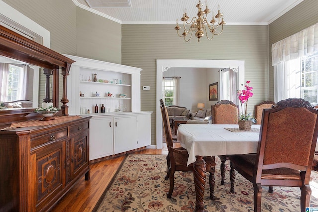 dining space featuring a notable chandelier, crown molding, and light hardwood / wood-style floors