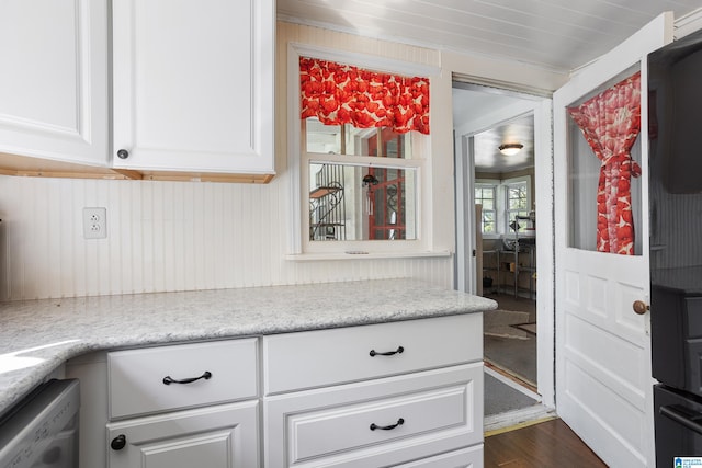 kitchen featuring white dishwasher, dark hardwood / wood-style flooring, light stone countertops, and white cabinets