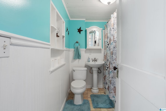 bathroom featuring tile patterned floors, crown molding, toilet, and sink