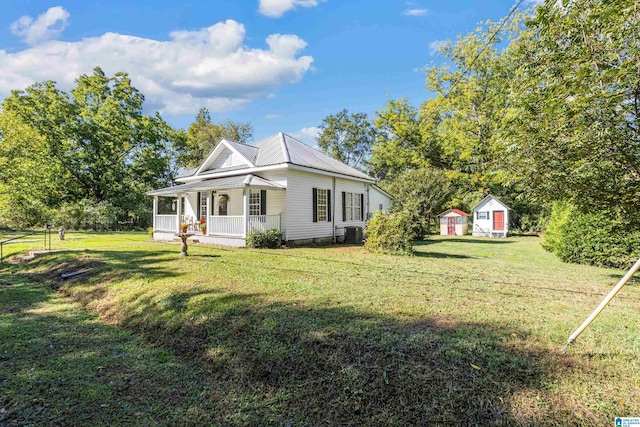 view of side of property with a lawn, covered porch, and central air condition unit