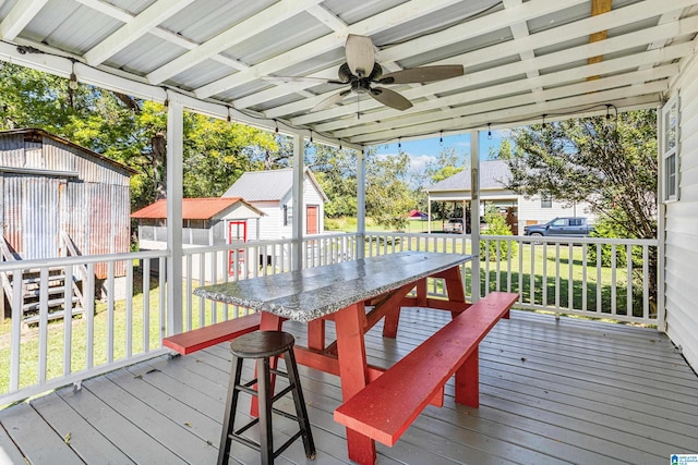 wooden deck featuring a storage shed, a yard, and ceiling fan