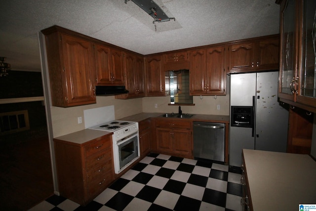 kitchen featuring appliances with stainless steel finishes, sink, and a textured ceiling