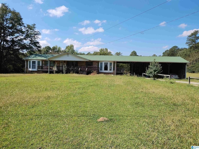 view of front facade featuring a front yard, metal roof, and a carport