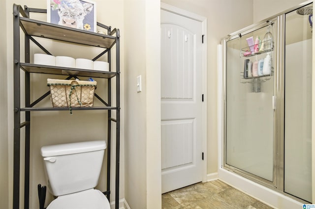 bathroom featuring toilet and a shower with door