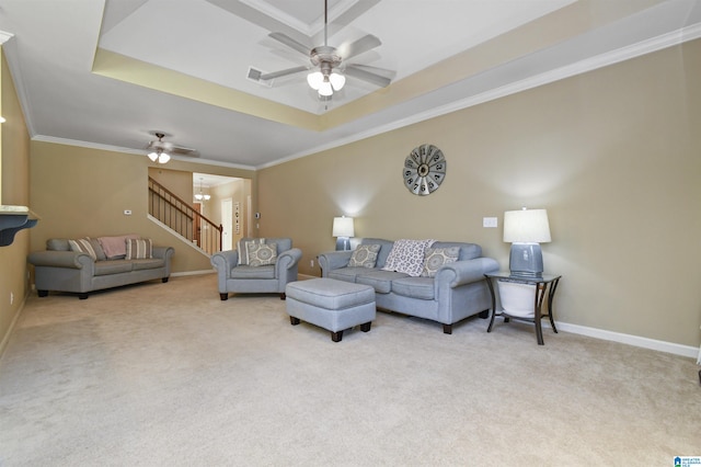 carpeted living room featuring a raised ceiling, ornamental molding, and ceiling fan