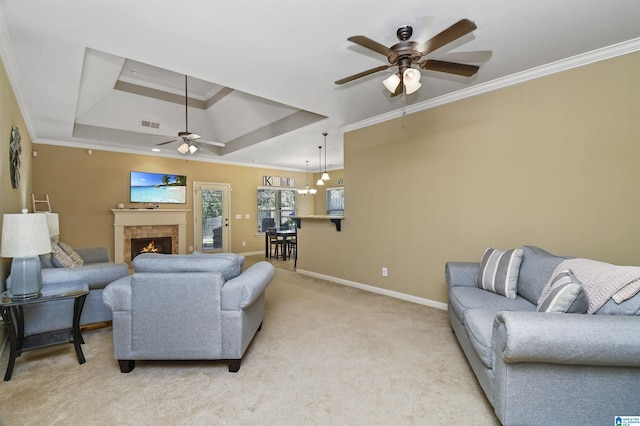 living room with ornamental molding, a raised ceiling, ceiling fan with notable chandelier, and light carpet