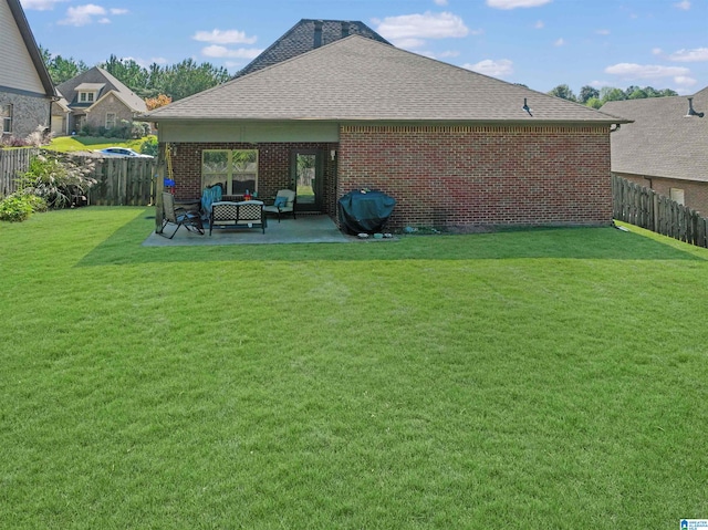 rear view of property with a lawn and a patio area