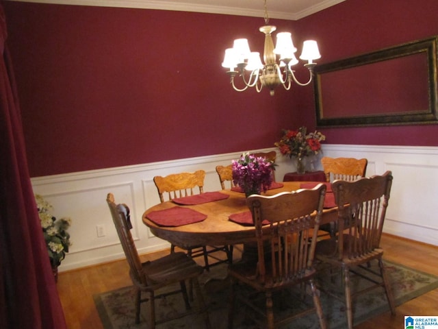 dining space with a chandelier, hardwood / wood-style flooring, and crown molding