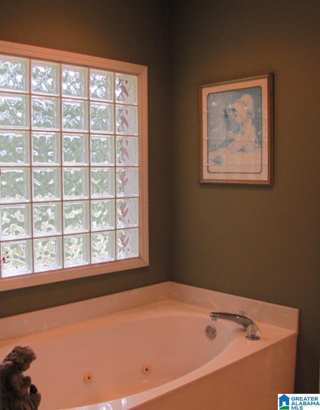 bathroom featuring a wealth of natural light and a bath