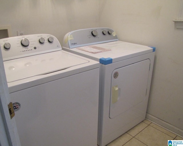 clothes washing area with washing machine and dryer and light tile patterned flooring