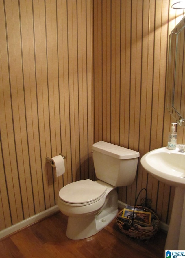 bathroom with wooden walls, hardwood / wood-style flooring, and toilet