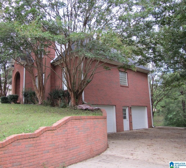 view of home's exterior with a garage and a lawn