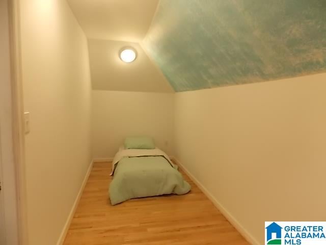 bedroom featuring wood-type flooring and lofted ceiling