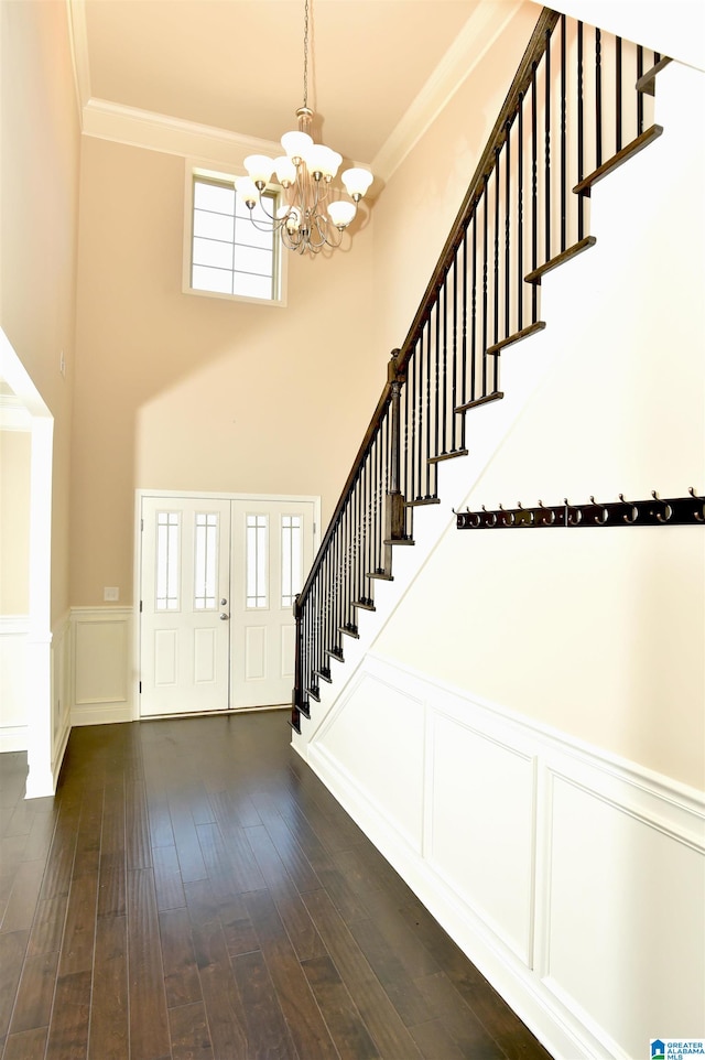 entryway featuring a chandelier, dark hardwood / wood-style floors, and crown molding