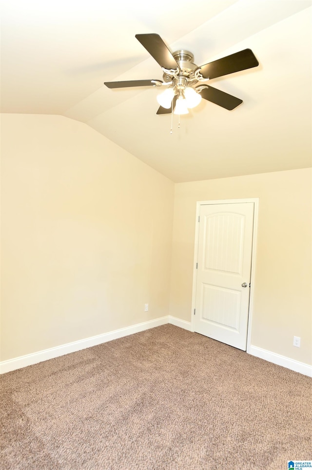 carpeted empty room with vaulted ceiling and ceiling fan