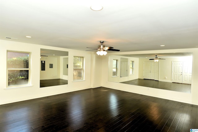 empty room with electric panel, ceiling fan, and dark hardwood / wood-style flooring