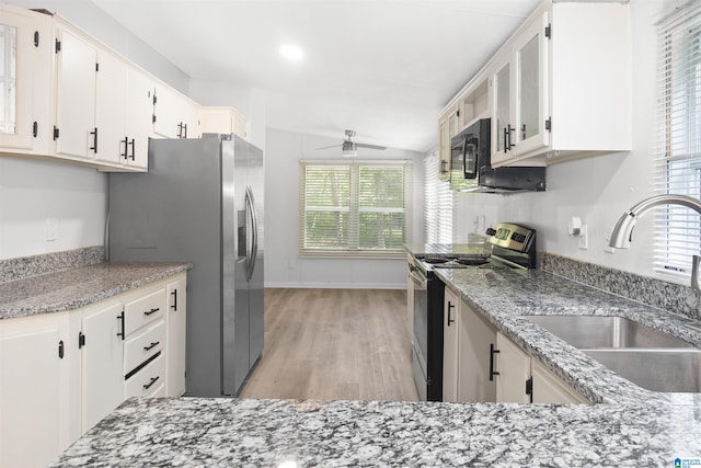 kitchen with light hardwood / wood-style floors, sink, lofted ceiling, white cabinetry, and appliances with stainless steel finishes