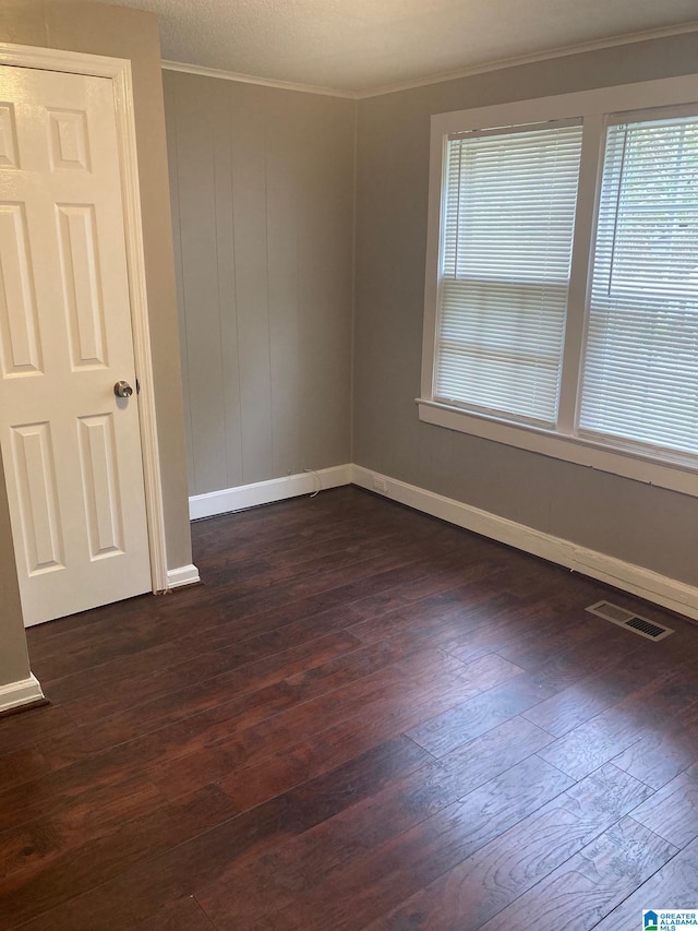 unfurnished room with crown molding and dark hardwood / wood-style floors