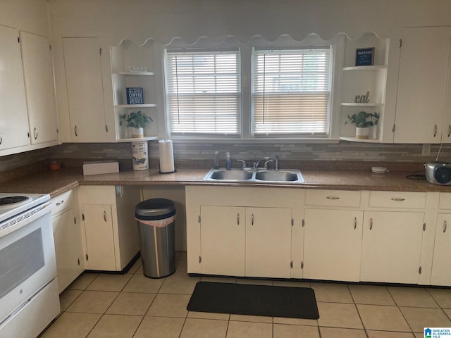 kitchen with tasteful backsplash, sink, white cabinetry, and white range with electric stovetop