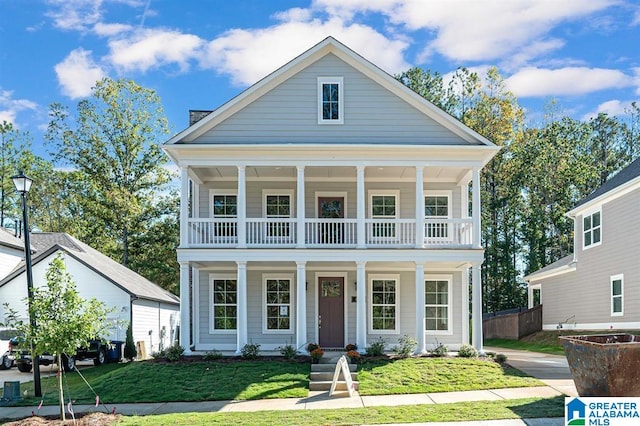 neoclassical / greek revival house featuring a front yard and a balcony