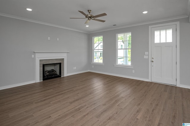 unfurnished living room featuring hardwood / wood-style floors, ceiling fan, ornamental molding, and a fireplace