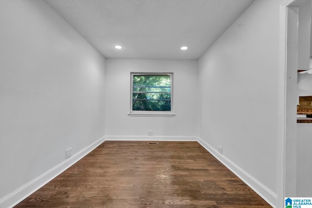 empty room with dark hardwood / wood-style flooring