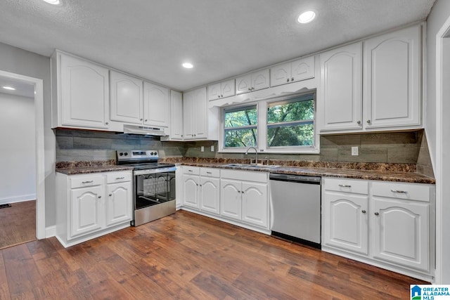 kitchen featuring dark wood-type flooring, sink, white cabinetry, appliances with stainless steel finishes, and backsplash