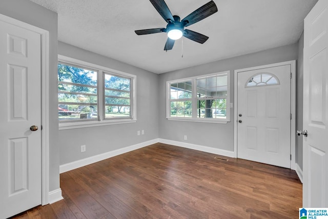 foyer with a textured ceiling, ceiling fan, and dark hardwood / wood-style flooring