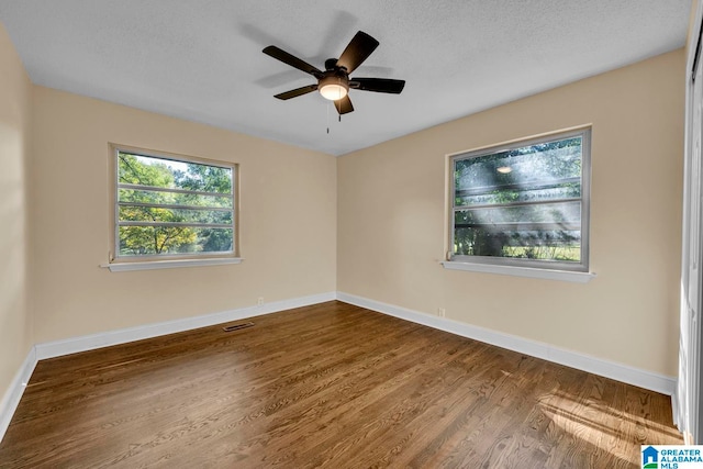 empty room featuring hardwood / wood-style flooring, ceiling fan, and a textured ceiling