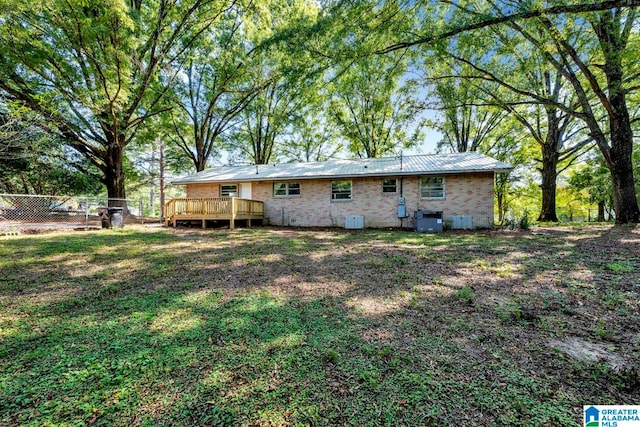 rear view of house with a yard, central AC, and a deck