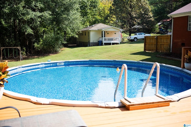 view of pool with a wooden deck and a yard