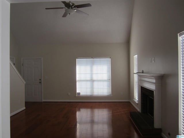 unfurnished living room featuring ceiling fan and dark wood-type flooring