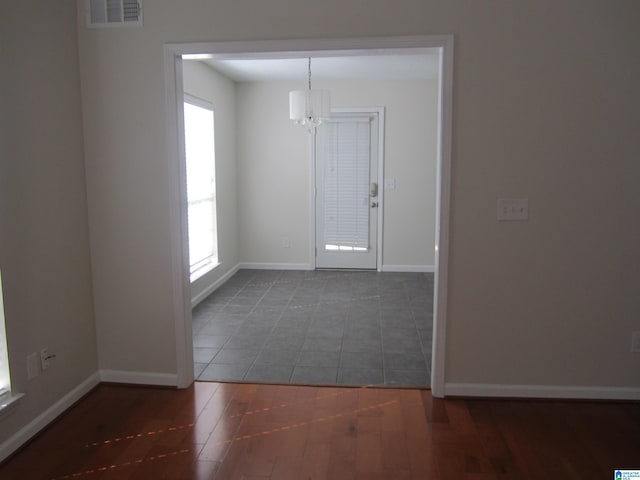 tiled foyer with an inviting chandelier