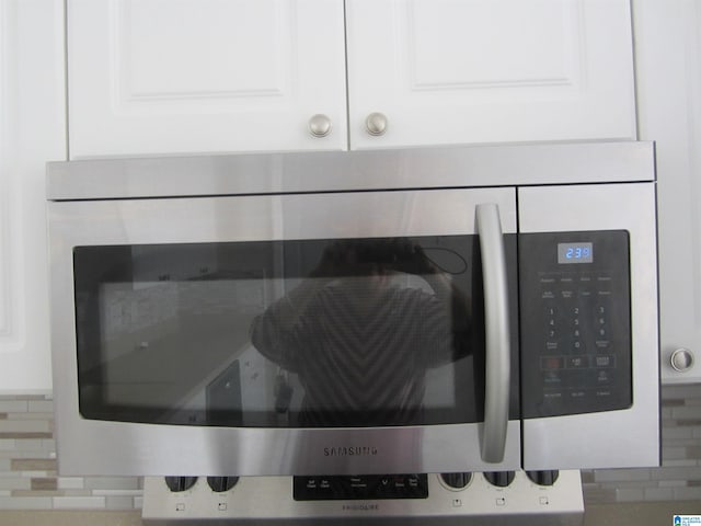 details featuring white cabinets and tasteful backsplash