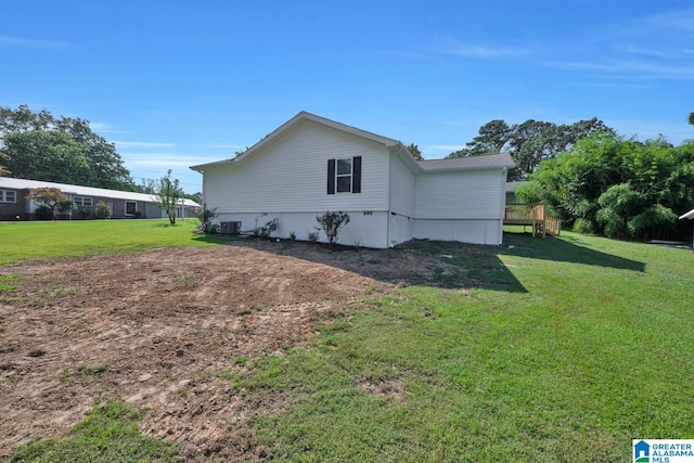 view of side of property featuring a yard and central AC unit