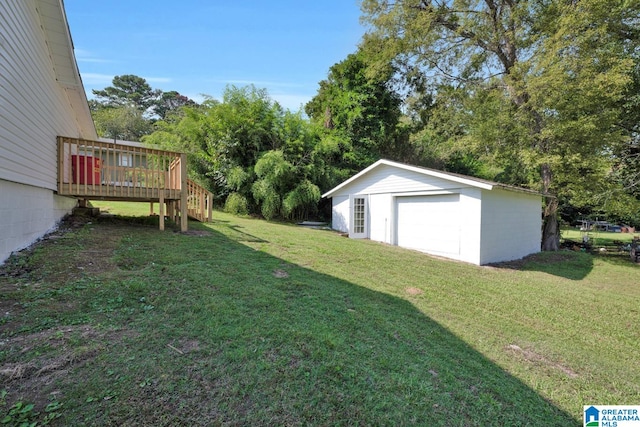 view of yard featuring a garage, an outbuilding, and a deck