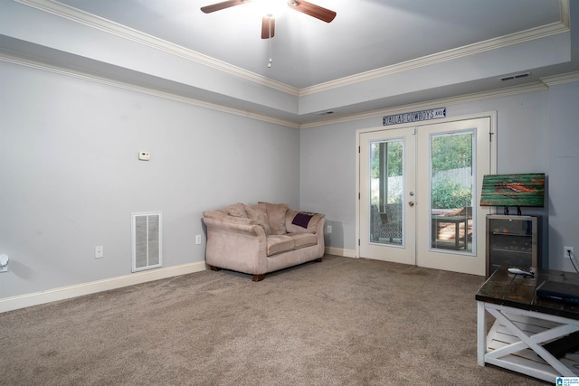 living area with carpet, a raised ceiling, crown molding, ceiling fan, and french doors