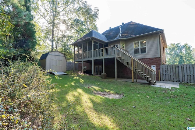 rear view of property featuring a storage shed, a sunroom, and a lawn